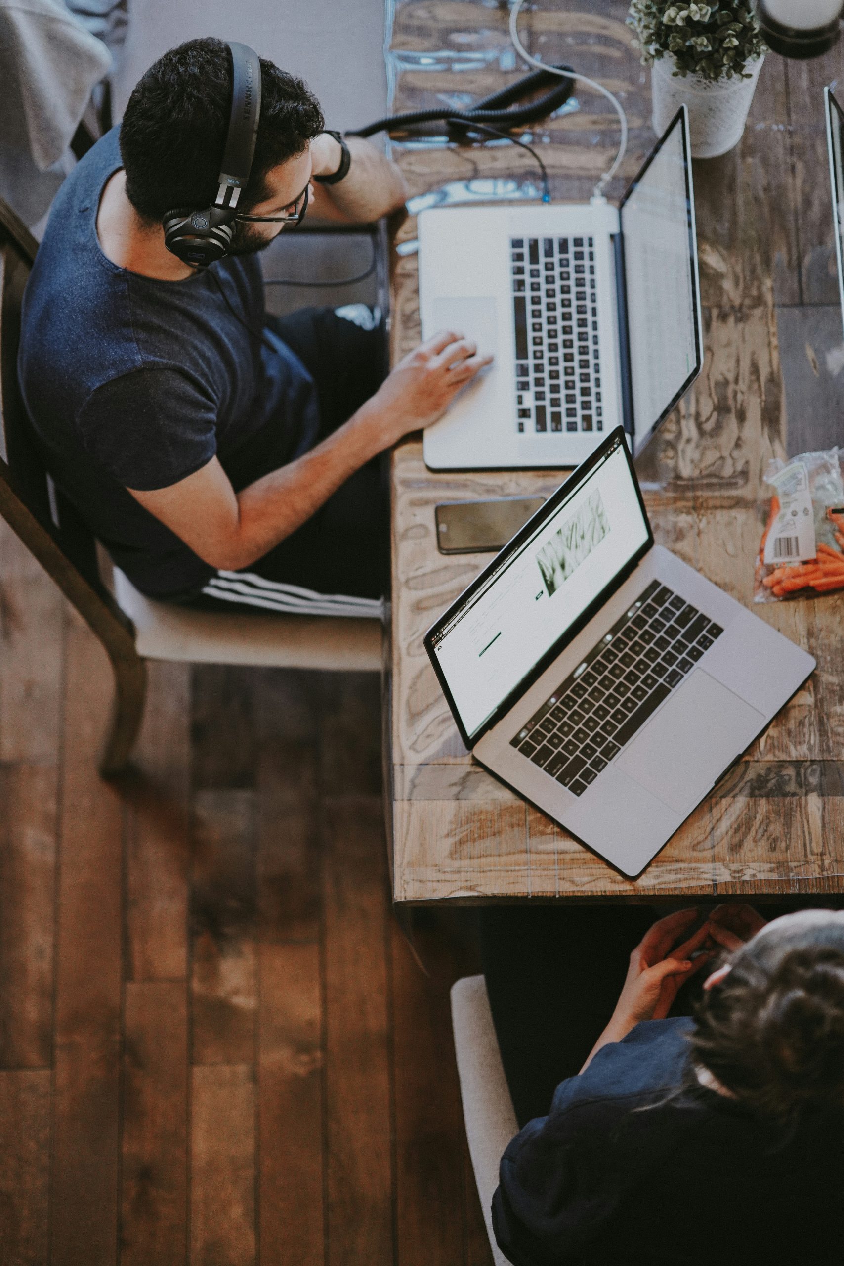 Two people working on laptops at a desk